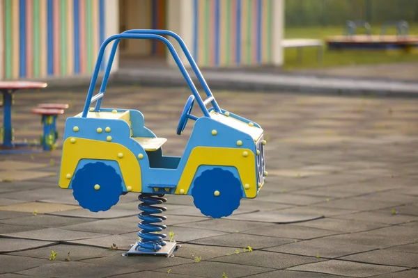 Parco giochi per bambini con auto giocattolo luminoso in primavera. Bambini. — Foto Stock