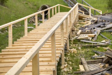 Yeni ahşap merdivenler açık havada. Marangozlar çalışır.