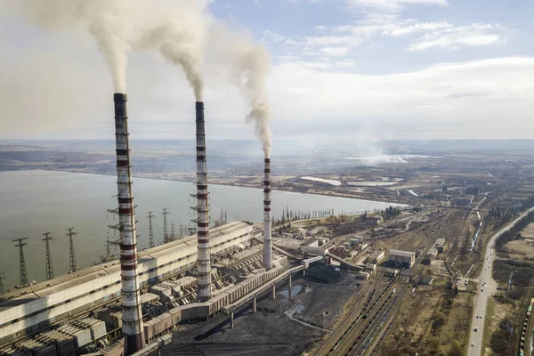 Високі труби електростанції, білий дим на сільському пейзажі, озеро — стокове фото