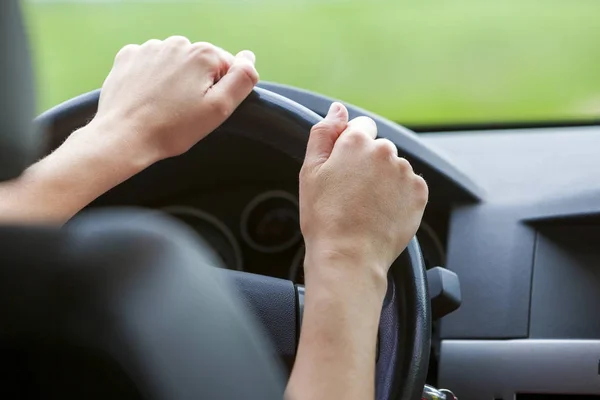 Mulher mãos no volante dirigindo um carro . — Fotografia de Stock