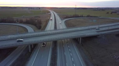 Hareket halindeki trafik arabalarıyla otoyol kavşağının havadan görüntüsü.