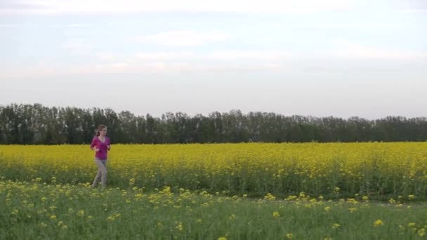 Junge Frau Läuft Durch Blühende Felder — Stockvideo