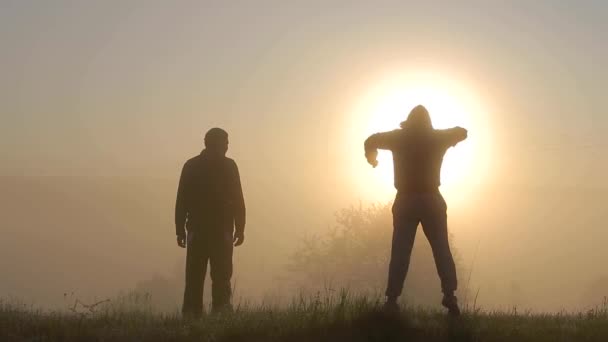 Güneş Doğarken Dışarıda Eğlenen Iki Adamın Karanlık Silueti — Stok video