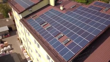 Endüstriyel binanın çatısında güneş panellerinin havadan görünümü.