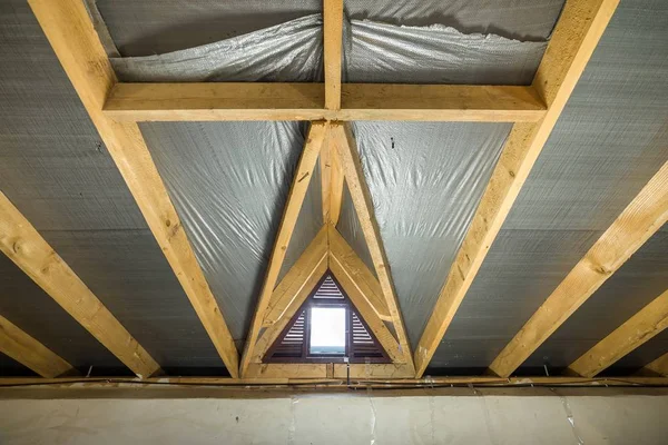 Ático de un edificio con vigas de madera de una estructura de techo y un —  Fotos de Stock
