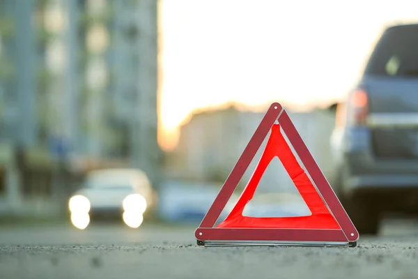 Красный аварийный треугольник знак остановки и сломанная машина на городской улице — стоковое фото