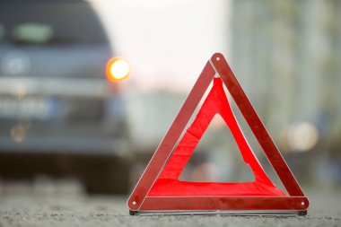 Kırmızı acil durum üçgeni dur işareti ve bir şehir caddesinde kırık araba