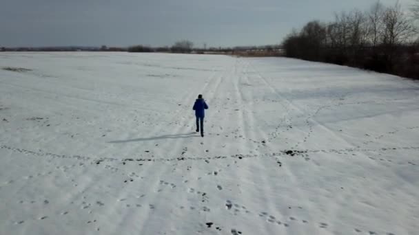 冬は雪上を走るかジョギングする男 — ストック動画