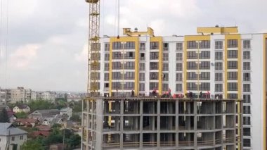 Yeni beton konut inşaatında çalışan inşaat işçileri.