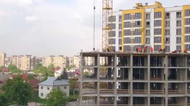 Yeni beton konut inşaatında çalışan inşaat işçileri.