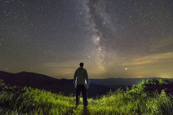 밤에 산에 서있는 남자의 어두운 실루엣을 즐기고 — 스톡 사진