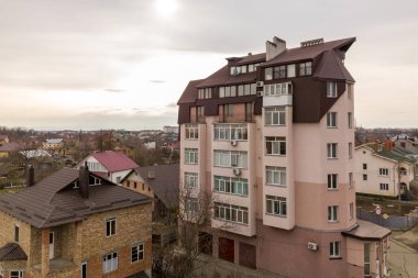 Birçok pencere ve metal levhaçatı ile yüksek apartman.
