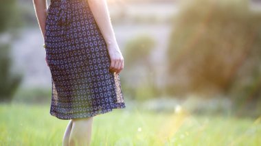 Yeşil çimenlerin tadını çıkaran bir tarlada tek başına duran genç kadın 