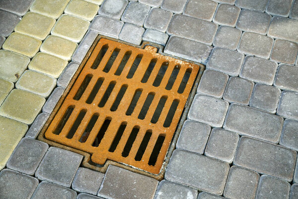 Старая ржавая металлическая канава для дождевой воды на каменной мощеной боковой
