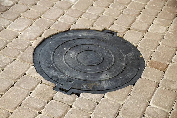 Antiguo canal de metal oxidado para el agua de lluvia en la piedra pavimentada sidewa —  Fotos de Stock