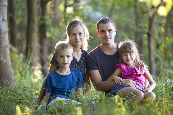 Family outdoors in forest. Portrait of young father, mother, dau