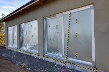Koruyucu pl ile kaplı inşaat altında bir evin Pencereleri