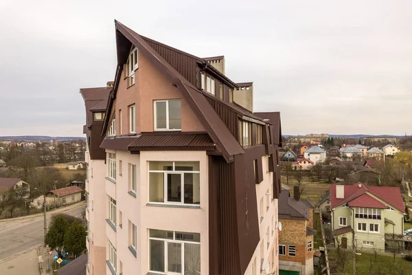 Wysoki budynek apartamentowy z wieloma oknami i dachami metalowymi. — Zdjęcie stockowe