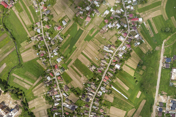 Top down aerial view of town or village with rows of buildings a