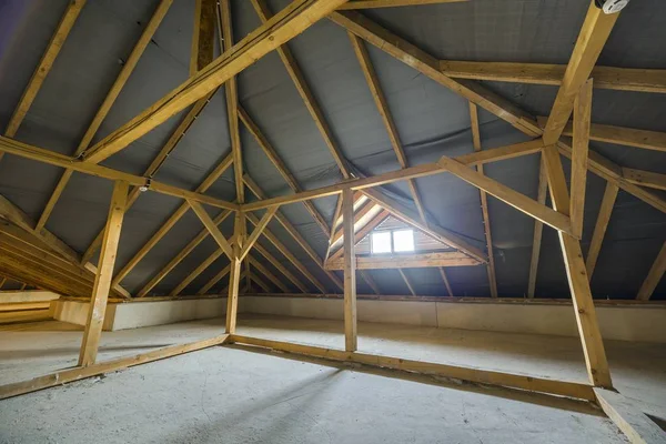 Mansarda di un edificio con travi in legno di una struttura di tetto e un — Foto Stock