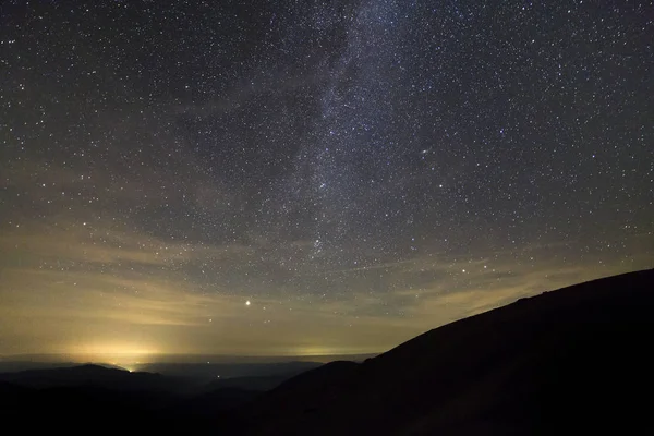 Paysage nocturne de montagnes avec ciel étoilé couvert  . — Photo