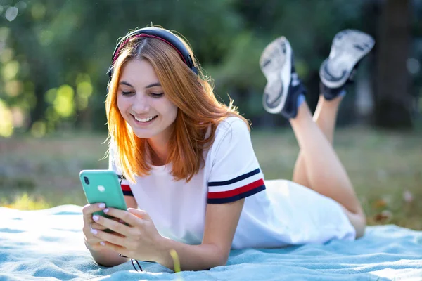 Adolescente bastante sonriente escuchando música en auriculares rosados —  Fotos de Stock