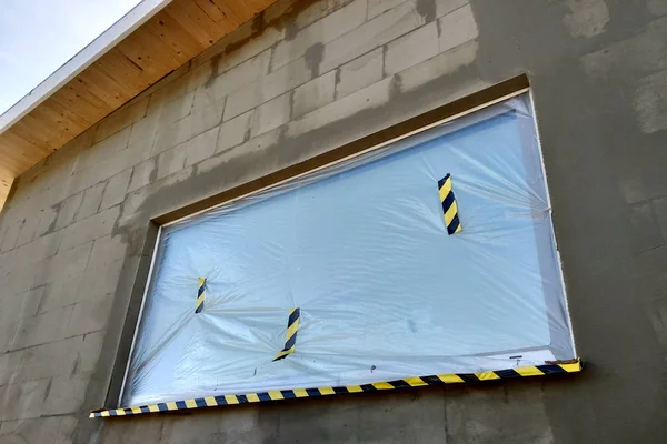Ventana de una casa en construcción cubierta con pla protector —  Fotos de Stock