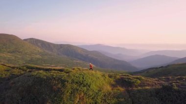 Sırt çantalı bir turist Carpathian dağlarında dağ yolunda koşuyor. Erkek turist kayalık çöl arazisinde koşuyor..