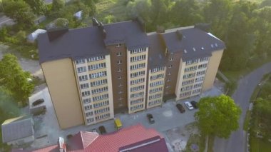 Yeşil yerleşim alanındaki çok katlı apartmanın havadan görünüşü.