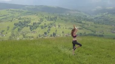 Genç kadın bir yaz günü dağ manzarasının tadını çıkarıyor. Doğa ortamında dinlenme ve meditasyon.