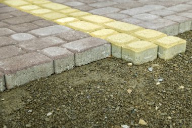 Bir avluya taş döşeme levhalarının montajı.