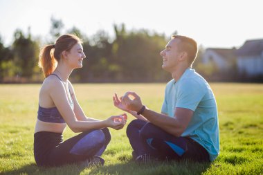 Genç çift dışarıda eğleniyor. Erkek ve kadın toget meditasyon