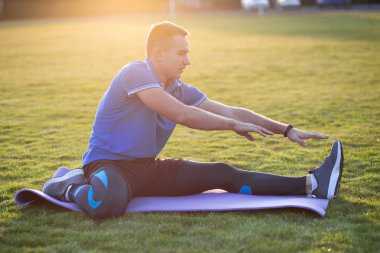Genç sporcu, koşmadan önce esneme egzersizleri yapıyor. 