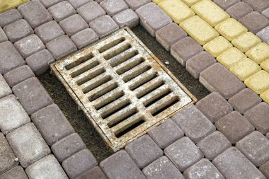 Taş asfalt sidewa yağmur suyu için eski paslı metal oluk
