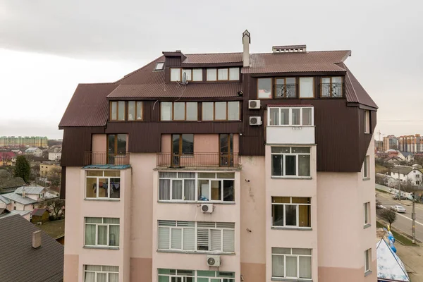 High apartment building with many windows and metal sheets roof. — Stock Photo, Image