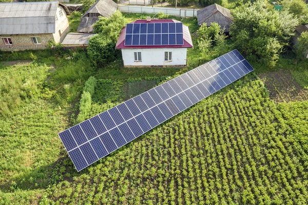 Вид с воздуха на дом с голубыми солнечными панелями для чистой энергии . — стоковое фото