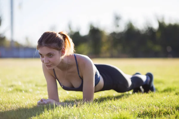 Молода спортивна жінка в спортивному одязі тренується в полі на сонці — стокове фото