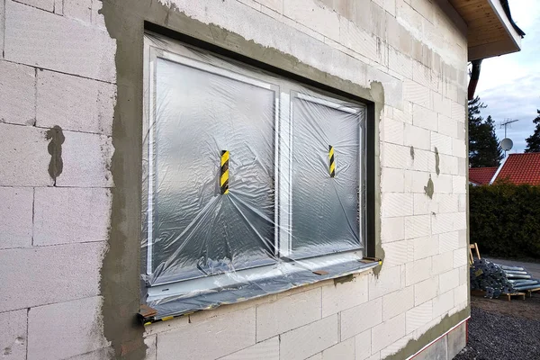 Вікно будинку, що будується, покритий захисною плитою — стокове фото