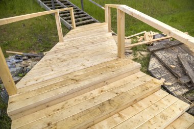 Yeni ahşap merdivenler açık havada. Marangozlar çalışır.