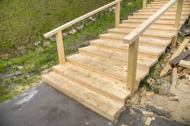 Yeni ahşap merdivenler açık havada. Marangozlar çalışır.