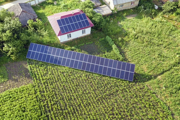 Letecký pohled na dům s modrými solárními panely pro čistou energii. — Stock fotografie