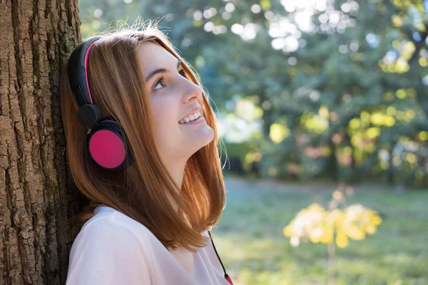 Portrét mladé černovlasé dívky poslouchající hudbu ve velkém pí — Stock fotografie