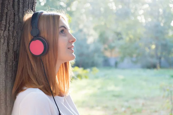 Portrét mladé černovlasé dívky poslouchající hudbu ve velkém pí — Stock fotografie
