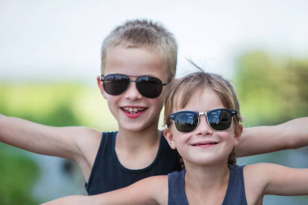 Dos niños en gafas de sol negras divirtiéndose al aire libre en suma — Foto de Stock