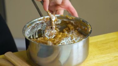 Kadın ellerine yakın durun. Fıstık hazırlıyorlar. Pasta için bir kase dolduruyorlar..