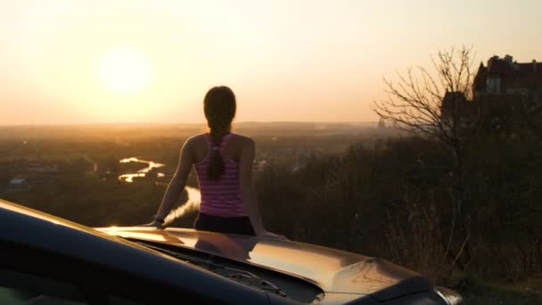 Mujer Joven Pie Cerca Coche Disfrutando Una Cálida Vista Atardecer — Vídeo de stock