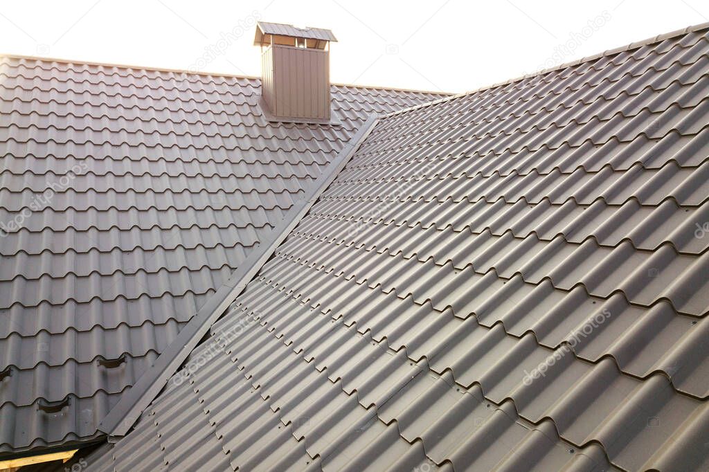 Close up of new house roof structure covered with metal tile sheets.