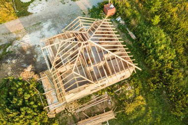 İnşaat halindeki ahşap çatılı bitmemiş tuğla evin havadan görüntüsü..