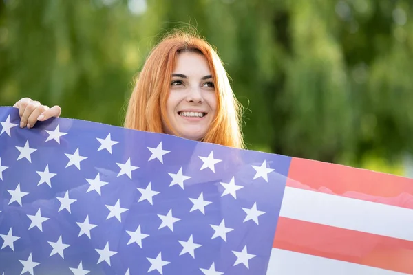 Młoda Rudowłosa Kobieta Trzymająca Flagę Usa Świeżym Powietrzu Letnim Parku — Zdjęcie stockowe