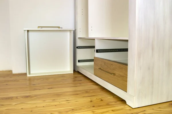 Close up of installation of wooden drawer in contemporary cupboard cabinet.